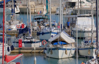 İtalya, Sicilya, Akdeniz, Marina di Ragusa (Ragusa ili); 21 Haziran 2025, limandaki bir yelkenli teknesinde çift - EDITORIAL