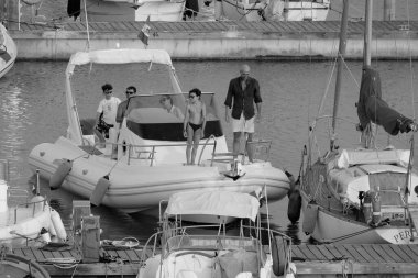 İtalya, Sicilya, Akdeniz, Marina di Ragusa (Ragusa ili); 21 Haziran 2025, limandaki kauçuk bir teknede insanlar - EDITORIAL