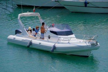 İtalya, Sicilya, Akdeniz, Marina di Ragusa (Ragusa ili); 22 Haziran 2025, limandaki kauçuk bir teknede insanlar - EDITORIAL