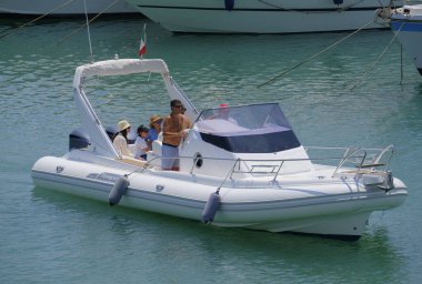 İtalya, Sicilya, Akdeniz, Marina di Ragusa (Ragusa ili); 22 Haziran 2025, limandaki kauçuk bir teknede insanlar - EDITORIAL