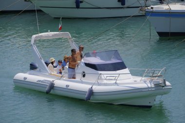 İtalya, Sicilya, Akdeniz, Marina di Ragusa (Ragusa ili); 22 Haziran 2025, limandaki kauçuk bir teknede insanlar - EDITORIAL