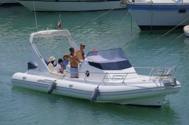 İtalya, Sicilya, Akdeniz, Marina di Ragusa (Ragusa ili); 22 Haziran 2025, limandaki kauçuk bir teknede insanlar - EDITORIAL