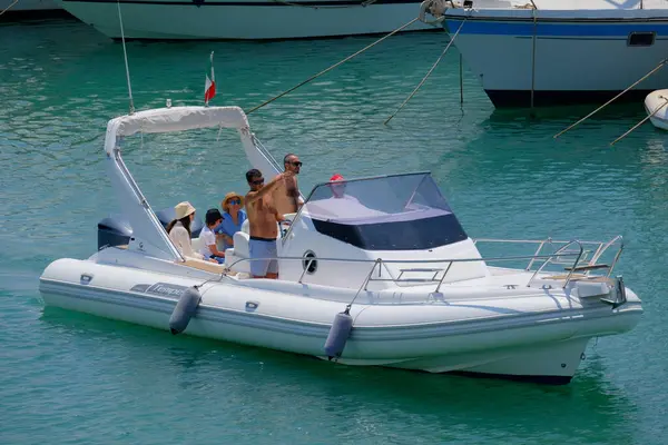 İtalya, Sicilya, Akdeniz, Marina di Ragusa (Ragusa ili); 22 Haziran 2025, limandaki kauçuk bir teknede insanlar - EDITORIAL