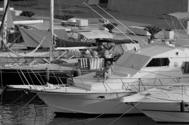 İtalya, Sicilya, Akdeniz, Marina di Ragusa (Ragusa ili); 22 Haziran 2025, limanda lüks bir yatta çift - EDITORIAL