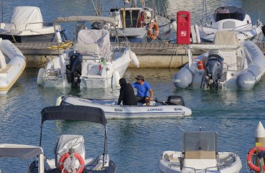 İtalya, Sicilya, Akdeniz, Marina di Ragusa (Ragusa ili); 24 Haziran 2025, limandaki kauçuk bir teknede adamlar - EDITORIAL