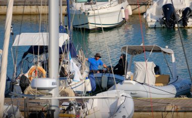 İtalya, Sicilya, Akdeniz, Marina di Ragusa (Ragusa ili); 24 Haziran 2025, limandaki kauçuk bir teknede adamlar - EDITORIAL