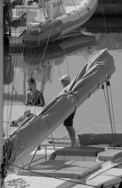 İtalya, Sicilya, Akdeniz, Marina di Ragusa (Ragusa ili); 25 Haziran 2025, limanda bir katamaran yelkenli teknesinde çift - EDITORIAL