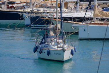 İtalya, Sicilya, Akdeniz, Marina di Ragusa (Ragusa Eyaleti); 25 Haziran 2025, limandaki bir yelkenli ve lüks yatlarda adam - EDITORIAL