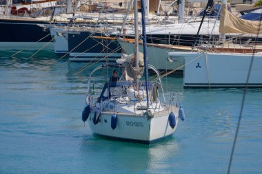 İtalya, Sicilya, Akdeniz, Marina di Ragusa (Ragusa Eyaleti); 25 Haziran 2025, limandaki bir yelkenli ve lüks yatlarda adam - EDITORIAL