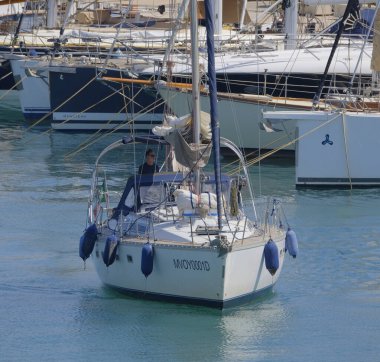 İtalya, Sicilya, Akdeniz, Marina di Ragusa (Ragusa Eyaleti); 25 Haziran 2025, limandaki bir yelkenli ve lüks yatlarda adam - EDITORIAL