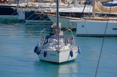 İtalya, Sicilya, Akdeniz, Marina di Ragusa (Ragusa Eyaleti); 25 Haziran 2025, limandaki bir yelkenli ve lüks yatlarda adam - EDITORIAL