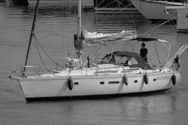 İtalya, Sicilya, Akdeniz, Marina di Ragusa (Ragusa Eyaleti); 25 Haziran 2025, limandaki bir yelkenli ve lüks yatlarda adam - EDITORIAL