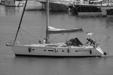 İtalya, Sicilya, Akdeniz, Marina di Ragusa (Ragusa Eyaleti); 25 Haziran 2025, limandaki bir yelkenli ve lüks yatlarda adam - EDITORIAL