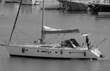 İtalya, Sicilya, Akdeniz, Marina di Ragusa (Ragusa Eyaleti); 25 Haziran 2025, limandaki bir yelkenli ve lüks yatlarda adam - EDITORIAL