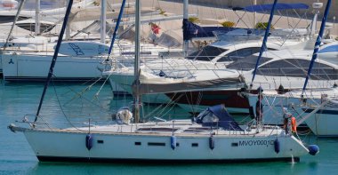 İtalya, Sicilya, Akdeniz, Marina di Ragusa (Ragusa Eyaleti); 25 Haziran 2025, limandaki bir yelkenli ve lüks yatlarda adam - EDITORIAL