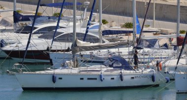 İtalya, Sicilya, Akdeniz, Marina di Ragusa (Ragusa Eyaleti); 25 Haziran 2025, limandaki bir yelkenli ve lüks yatlarda adam - EDITORIAL