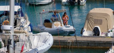 İtalya, Sicilya, Akdeniz, Marina di Ragusa (Ragusa ili); 27 Haziran 2025, limanda bir kauçuk teknede çift - EDITORIAL