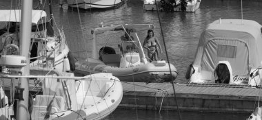 İtalya, Sicilya, Akdeniz, Marina di Ragusa (Ragusa ili); 27 Haziran 2025, limanda bir kauçuk teknede çift - EDITORIAL