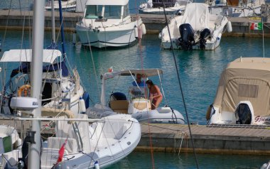 İtalya, Sicilya, Akdeniz, Marina di Ragusa (Ragusa ili); 27 Haziran 2025, limanda bir kauçuk teknede çift - EDITORIAL