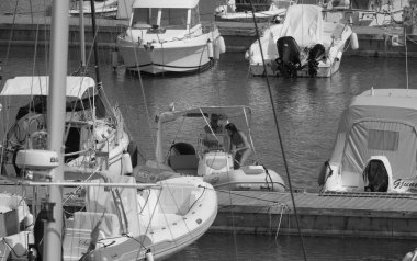 İtalya, Sicilya, Akdeniz, Marina di Ragusa (Ragusa ili); 27 Haziran 2025, limanda bir kauçuk teknede çift - EDITORIAL