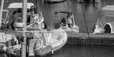 İtalya, Sicilya, Akdeniz, Marina di Ragusa (Ragusa ili); 27 Haziran 2025, limanda bir kauçuk teknede çift - EDITORIAL