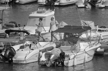 İtalya, Sicilya, Akdeniz, Marina di Ragusa (Ragusa ili); 27 Haziran 2025, limandaki insanlar, motorlu tekneler ve lüks yatlar - EDITORIAL