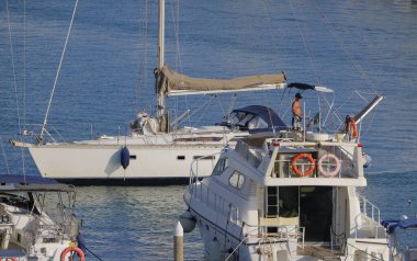 İtalya, Sicilya, Akdeniz, Marina di Ragusa (Ragusa Eyaleti); 27 Haziran 2025, limandaki bir yelkenli ve lüks yatlarda adam - EDITORIAL