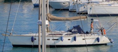 İtalya, Sicilya, Akdeniz, Marina di Ragusa (Ragusa Eyaleti); 27 Haziran 2025, limandaki bir yelkenli ve lüks yatlarda adam - EDITORIAL