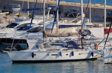 İtalya, Sicilya, Akdeniz, Marina di Ragusa (Ragusa Eyaleti); 27 Haziran 2025, limandaki bir yelkenli ve lüks yatlarda adam - EDITORIAL