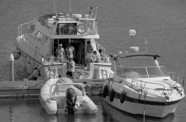 İtalya, Sicilya, Akdeniz, Marina di Ragusa (Ragusa Eyaleti); 29 Haziran 2025, erkekler limanda lüks bir yatta - EDITORIAL