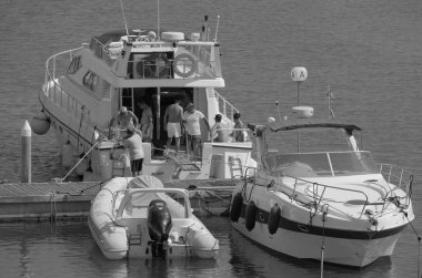 İtalya, Sicilya, Akdeniz, Marina di Ragusa (Ragusa Eyaleti); 29 Haziran 2025, erkekler limanda lüks bir yatta - EDITORIAL