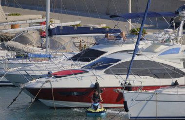 İtalya, Sicilya, Akdeniz, Marina di Ragusa (Ragusa Eyaleti); 2 Temmuz 2025, limandaki insanlar, motorlu tekneler ve lüks yatlar - EDITORIAL