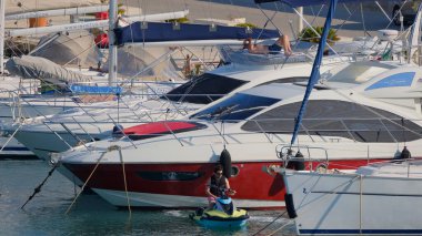 İtalya, Sicilya, Akdeniz, Marina di Ragusa (Ragusa Eyaleti); 2 Temmuz 2025, limandaki insanlar, motorlu tekneler ve lüks yatlar - EDITORIAL