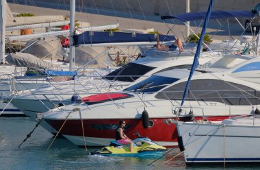 İtalya, Sicilya, Akdeniz, Marina di Ragusa (Ragusa Eyaleti); 2 Temmuz 2025, limandaki insanlar, motorlu tekneler ve lüks yatlar - EDITORIAL