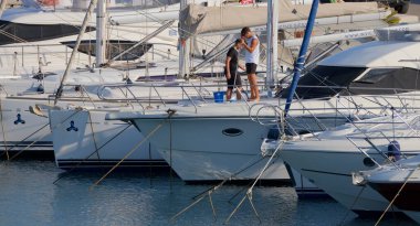 İtalya, Sicilya, Akdeniz, Marina di Ragusa (Ragusa ili); 9 Temmuz 2025; limanda lüks bir yatı temizleyen erkekler - EDITORIAL