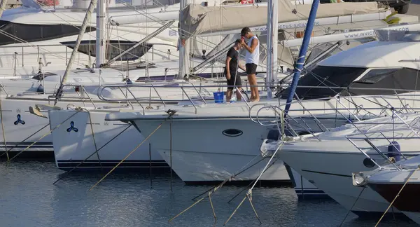 İtalya, Sicilya, Akdeniz, Marina di Ragusa (Ragusa ili); 9 Temmuz 2025; limanda lüks bir yatı temizleyen erkekler - EDITORIAL