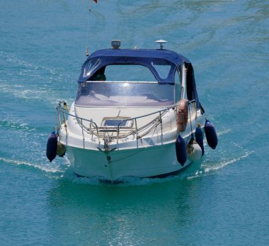 İtalya, Sicilya, Akdeniz, Marina di Ragusa (Ragusa Eyaleti); 13 Temmuz 2025, limandaki bir motorlu teknede adam - EDITORIAL