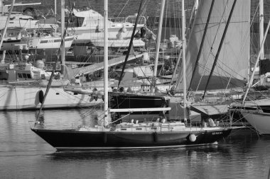 İtalya, Sicilya, Akdeniz, Marina di Ragusa (Ragusa Eyaleti); 16 Temmuz 2025, limanda bir yelkenli teknesi ve lüks yatlarda bir çift - EDITORIAL