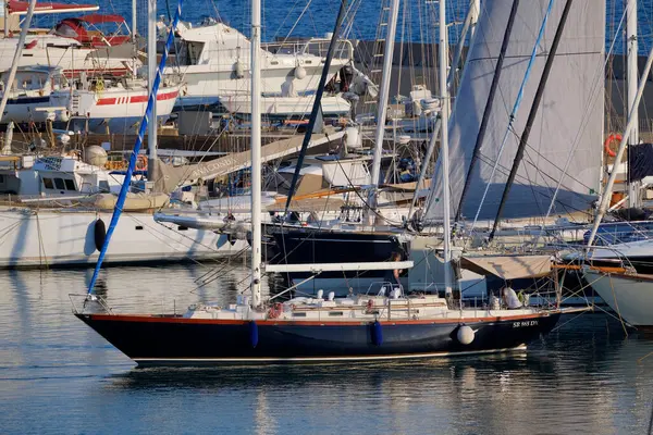 İtalya, Sicilya, Akdeniz, Marina di Ragusa (Ragusa Eyaleti); 16 Temmuz 2025, limanda bir yelkenli teknesi ve lüks yatlarda bir çift - EDITORIAL