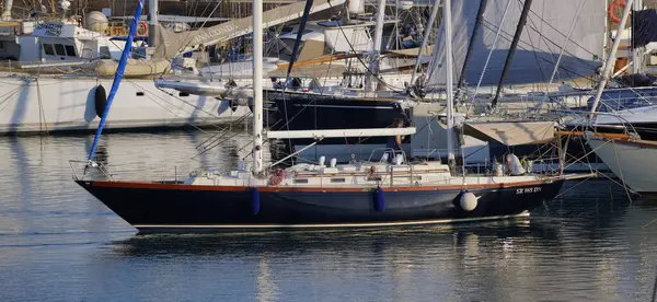 İtalya, Sicilya, Akdeniz, Marina di Ragusa (Ragusa Eyaleti); 16 Temmuz 2025, limanda bir yelkenli teknesi ve lüks yatlarda bir çift - EDITORIAL