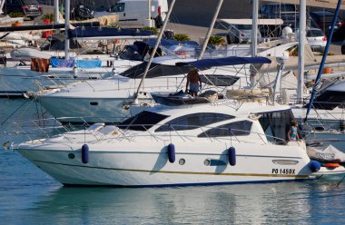 İtalya, Sicilya, Akdeniz, Marina di Ragusa (Ragusa Eyaleti); 19 Temmuz 2025, limanda lüks bir yatta çift - EDITORIAL