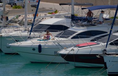 İtalya, Sicilya, Akdeniz, Marina di Ragusa (Ragusa Eyaleti); 20 Temmuz 2025, limanda lüks bir yatta insanlar - EDITORIAL