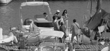 İtalya, Sicilya, Akdeniz, Marina di Ragusa (Ragusa Eyaleti); 20 Temmuz 2025, limandaki büyük bir kauçuk teknede insanlar - EDITORIAL