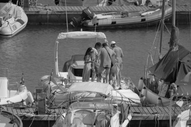 İtalya, Sicilya, Akdeniz, Marina di Ragusa (Ragusa Eyaleti); 20 Temmuz 2025, limandaki büyük bir kauçuk teknede insanlar - EDITORIAL