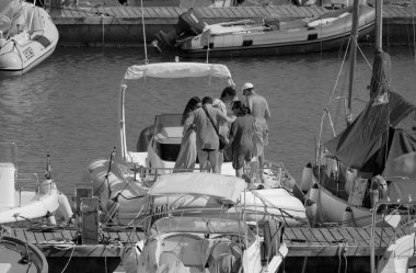 İtalya, Sicilya, Akdeniz, Marina di Ragusa (Ragusa Eyaleti); 20 Temmuz 2025, limandaki büyük bir kauçuk teknede insanlar - EDITORIAL