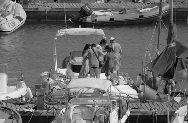 İtalya, Sicilya, Akdeniz, Marina di Ragusa (Ragusa Eyaleti); 20 Temmuz 2025, limandaki büyük bir kauçuk teknede insanlar - EDITORIAL