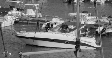 İtalya, Sicilya, Akdeniz, Marina di Ragusa (Ragusa Eyaleti); 20 Temmuz 2025, limanda lüks bir yatta insanlar - EDITORIAL