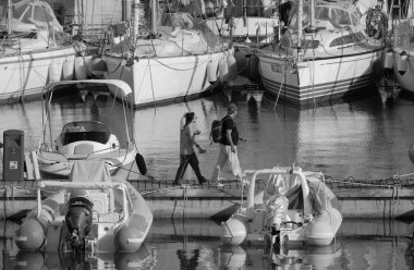 İtalya, Sicilya, Akdeniz, Marina di Ragusa (Ragusa ili); 23 Temmuz 2025, limandaki insanlar, motorlu tekneler ve lüks yatlar - EDITORIAL