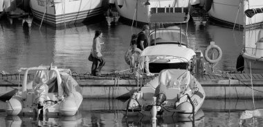 İtalya, Sicilya, Akdeniz, Marina di Ragusa (Ragusa ili); 23 Temmuz 2025, limandaki insanlar, motorlu tekneler ve lüks yatlar - EDITORIAL