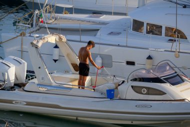 İtalya, Sicilya, Akdeniz, Marina di Ragusa (Ragusa Eyaleti); 23 Temmuz 2025, limandaki büyük bir lastik teknede adam - EDITORIAL